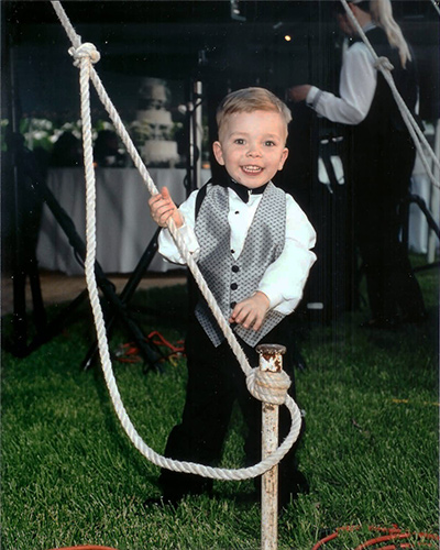 little groomsman at tent stake